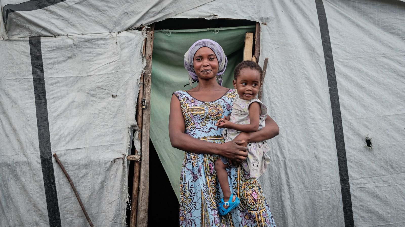 Une femme qui tient son enfant dans ses bras.